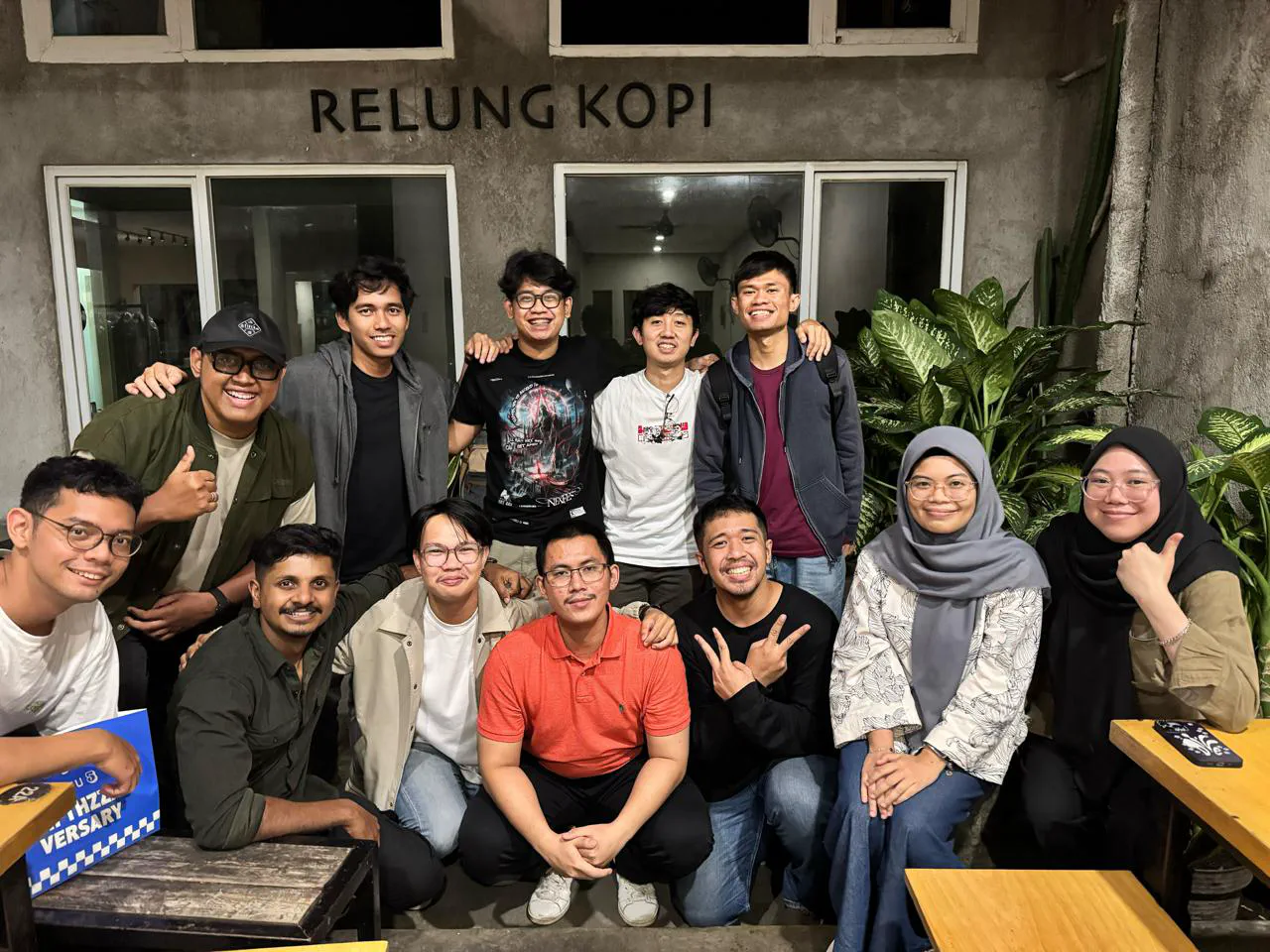 A big group posing at night in front of the Relung Kopi café.